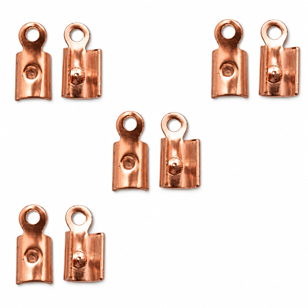 Six small copper-colored metal jump rings or connector pieces arranged on a plain white background.