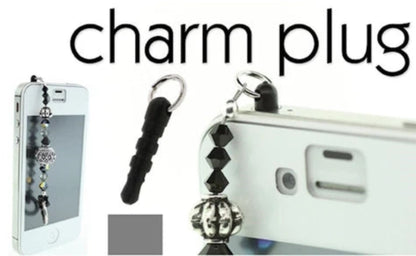 A phone charm plug accessory shown attached to a white phone, with a black textured loop and silver metal keychain ring. The image includes the text 'charm plug' at the top and a small gray square swatch near the bottom.