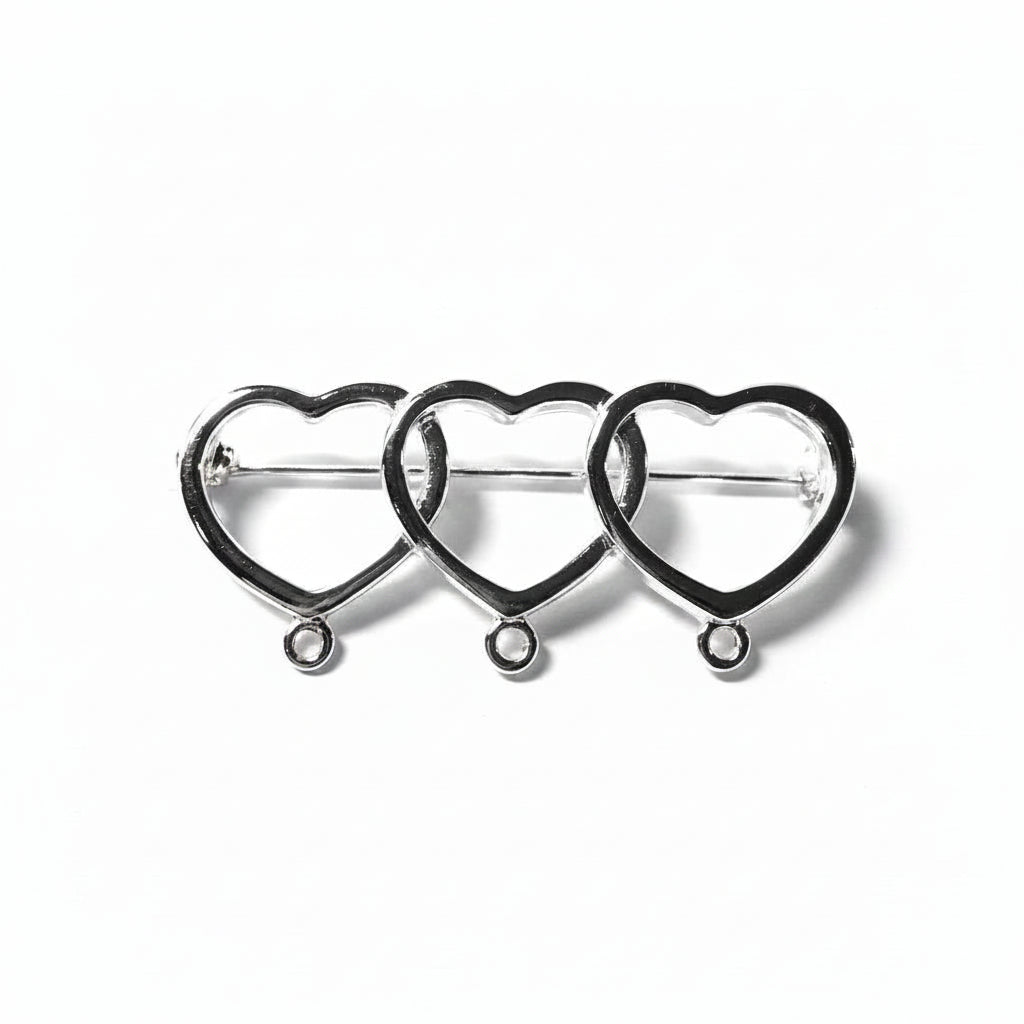 Three interlocking silver heart-shaped metal clasps or connectors arranged in a row on a light gray background.