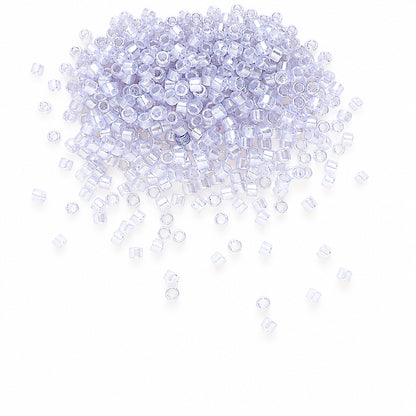 GLASS seed beads with a light lavender-blue tint, scattered across a white background.