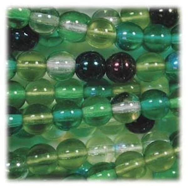 Green translucent glass beads and a few dark opaque beads arranged closely together on a green background.
