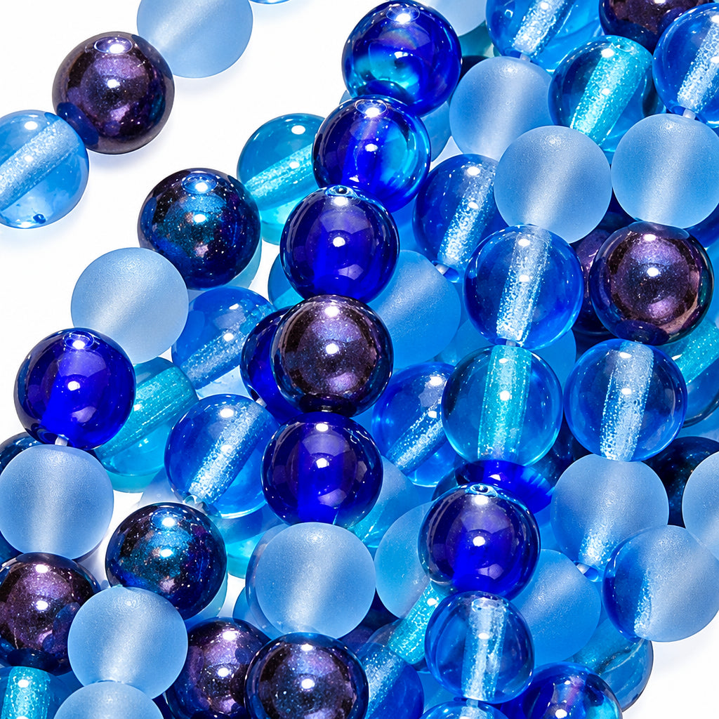 A close-up pile of round glass beads in various shades of blue, including translucent light blue, medium blue, and deep cobalt blue with some purple iridescence.