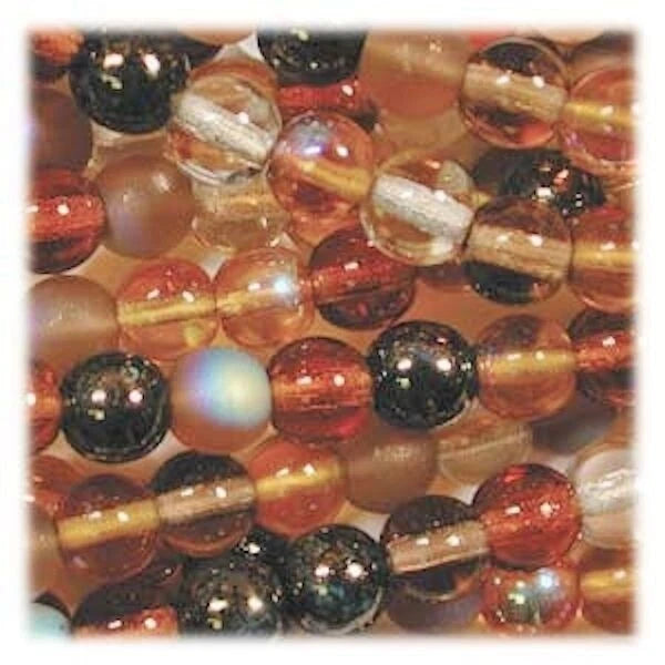 A close-up of round glass beads in warm tones, including amber, orange, translucent clear, and dark black marbled beads, arranged tightly together.