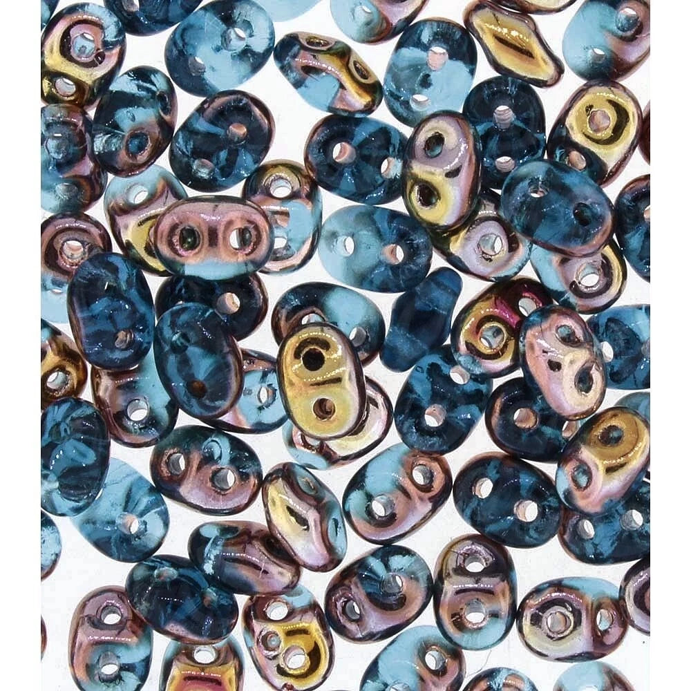 A close-up pile of small, irregular-shaped glass beads with a marbled pattern in shades of blue, purple, pink, and metallic gold, each featuring two holes.