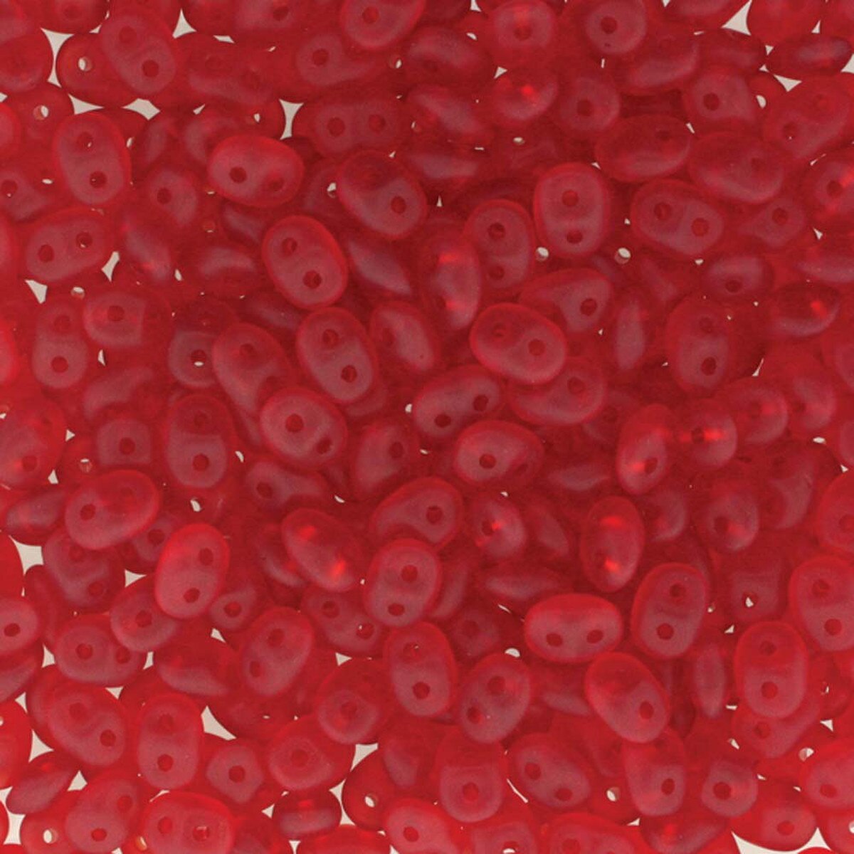A close-up, top-down view of numerous small, translucent red seed beads with a double hole, filling the entire frame.