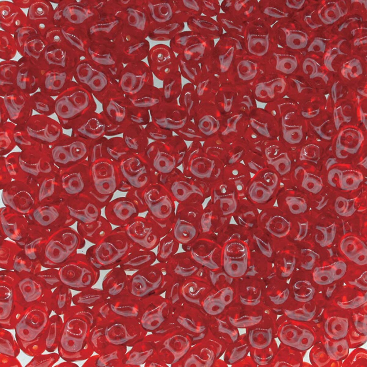 A dense pile of small, glossy, teardrop-shaped red beads with a central hole, filling the entire frame.