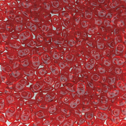 A dense pile of small, glossy, teardrop-shaped red beads with a central hole, filling the entire frame.