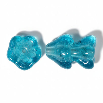 Two translucent turquoise blue beads, one flower-shaped and one mushroom-shaped, shown on a plain white background.