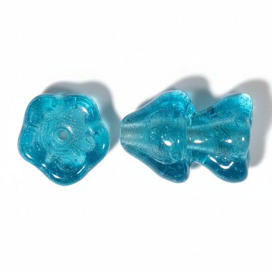 Two translucent turquoise blue beads, one flower-shaped and one mushroom-shaped, shown on a plain white background.