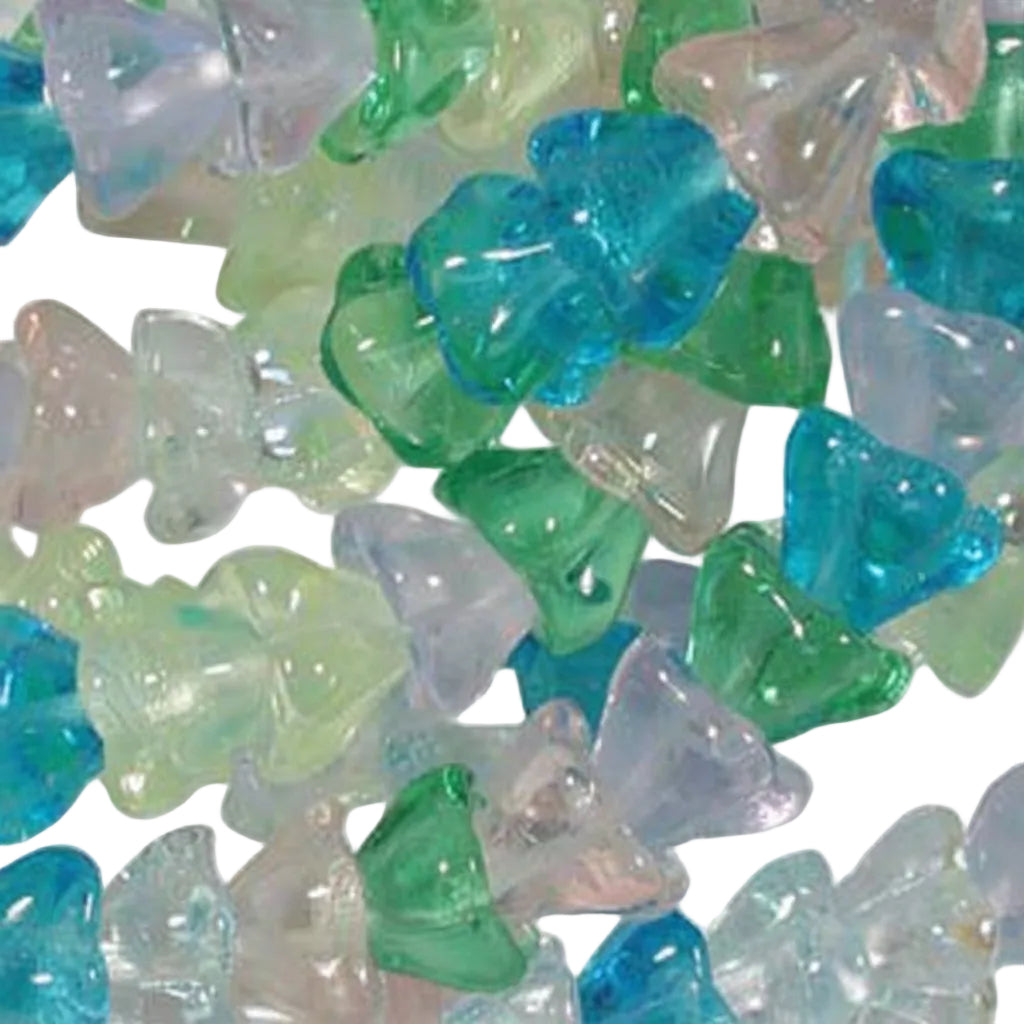 A close-up pile of small translucent triangular beads or stones in assorted pastel and bright colors, including blue, green, aqua, and pale pink, on a white background.