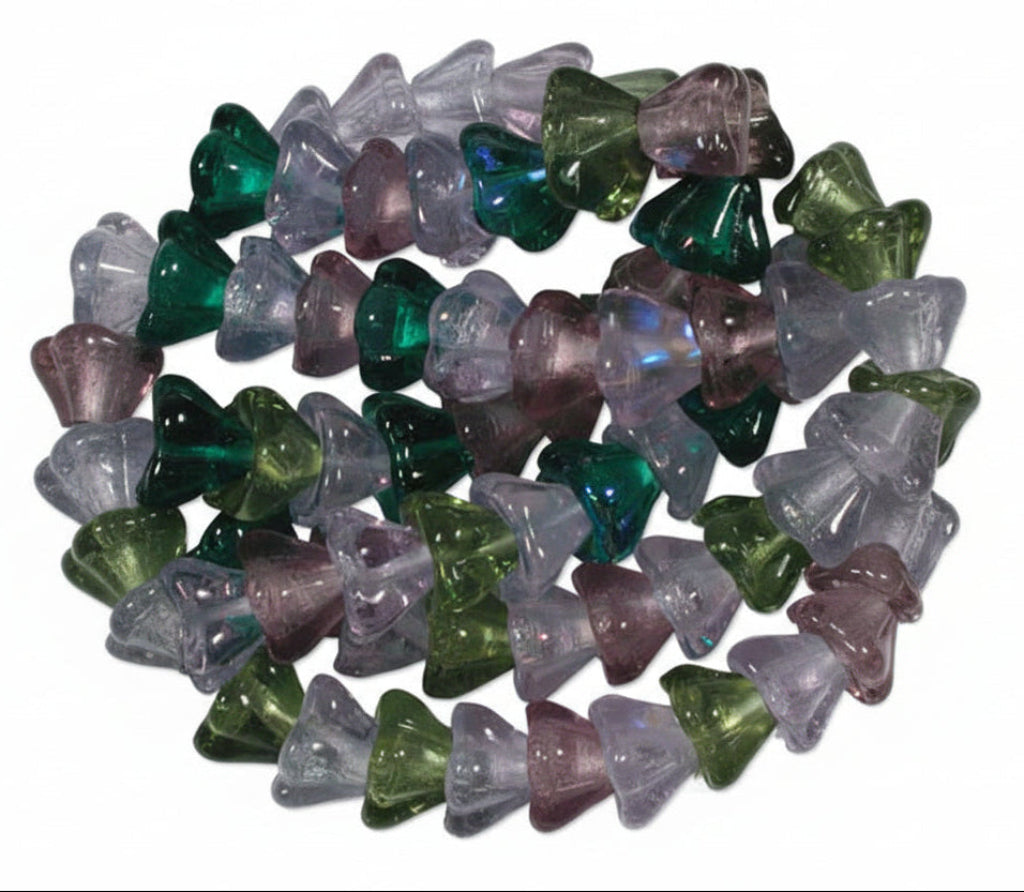 A close-up pile of small faceted gemstone chips in translucent shades of green, purple, and lavender on a white background.