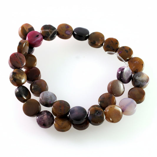 A beaded necklace made of polished, irregular-shaped gemstone beads in earthy brown, black, and purple tones, arranged in a circle on a plain white background.