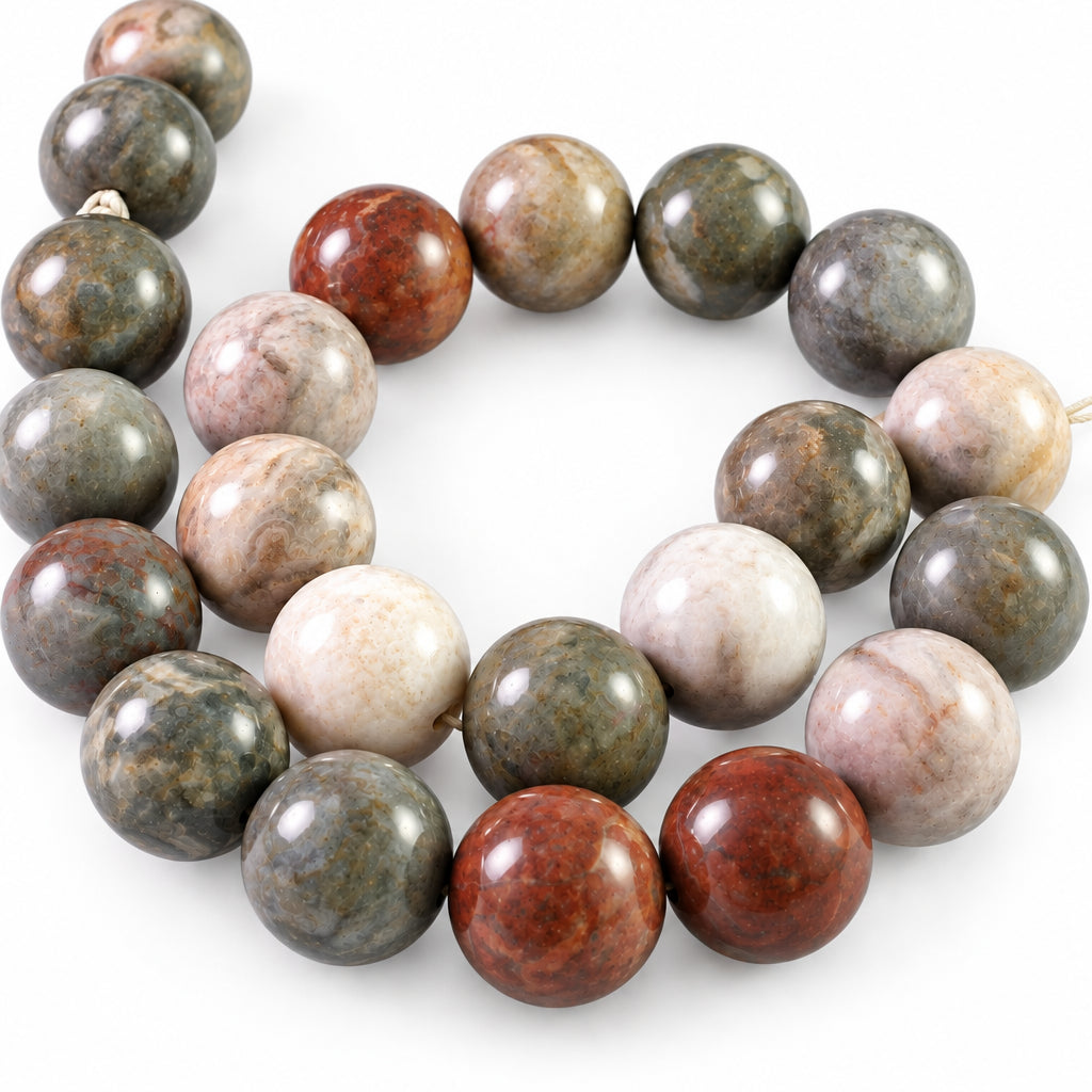 A strand of polished round gemstone beads in earthy gray, brown, white, and reddish tones, arranged in a loop on a plain white background.
