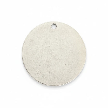 A blank, round silver metal tag with a small hanging hole at the top, shown on a solid white background.