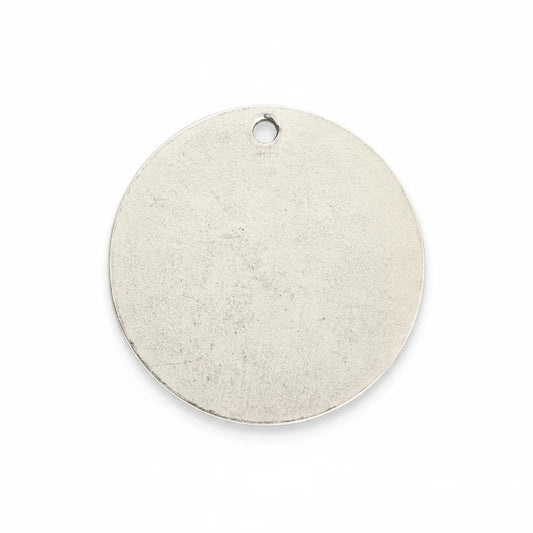 A blank, round silver metal tag with a small hanging hole at the top, shown on a solid white background.