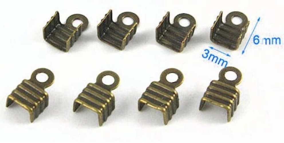 Eight small metal U-shaped findings with loop holes, shown in a bronze finish on a white background. Two blue dimension arrows indicate measurements of 3mm and 6mm.