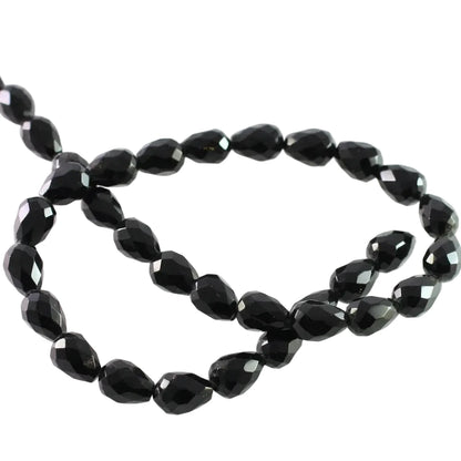 Faceted black glass beads arranged in a loose circle on a plain white background.