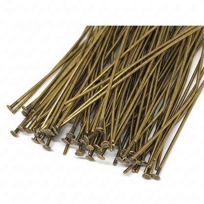 A pile of long, thin metallic pins with round heads, shown on a plain white background.