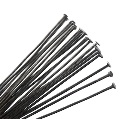 A bundle of long, thin black metal wire ties or zip-ties fanned out against a plain white background.