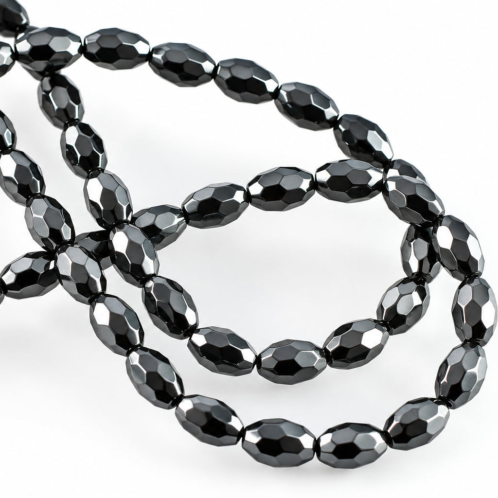Faceted black beads arranged in loops on a plain white background.