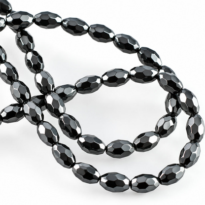 Faceted black beads arranged in loops on a plain white background.
