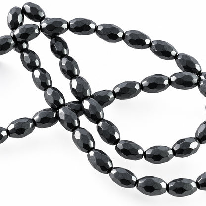 Faceted black glass beads on a plain white background.
