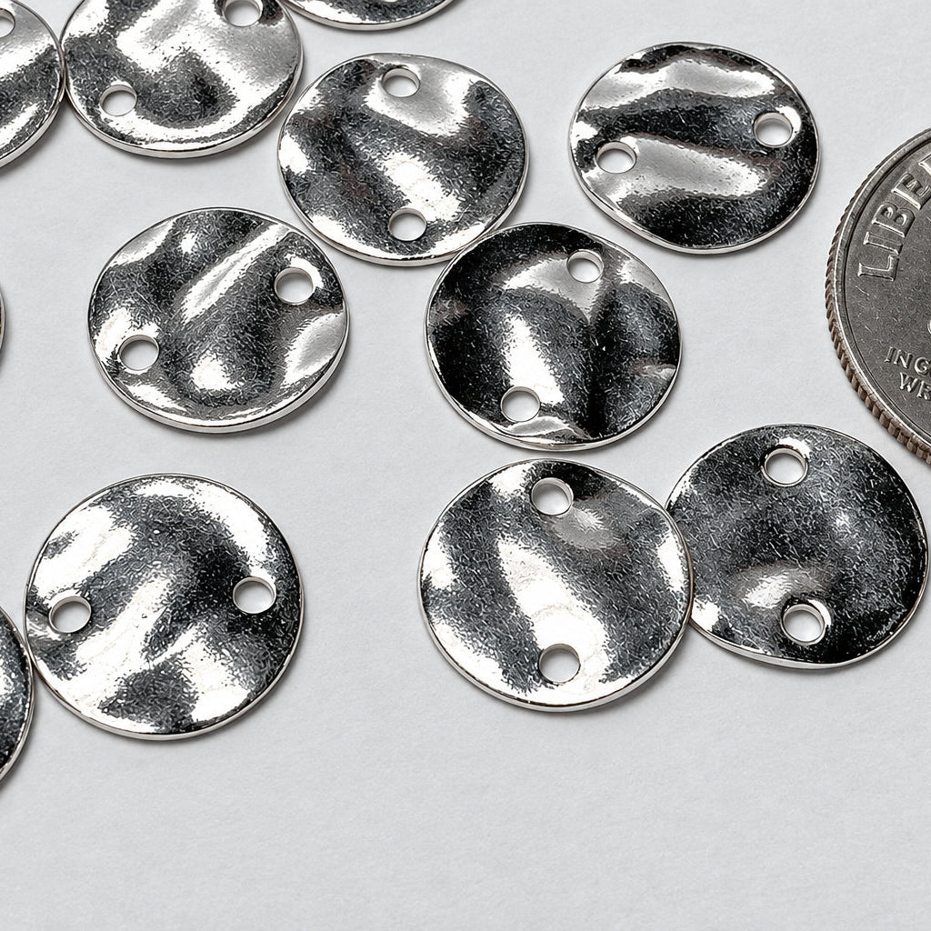 Several small round silver metal disc charms with three pre-drilled holes, shown on a light gray background with a U.S.