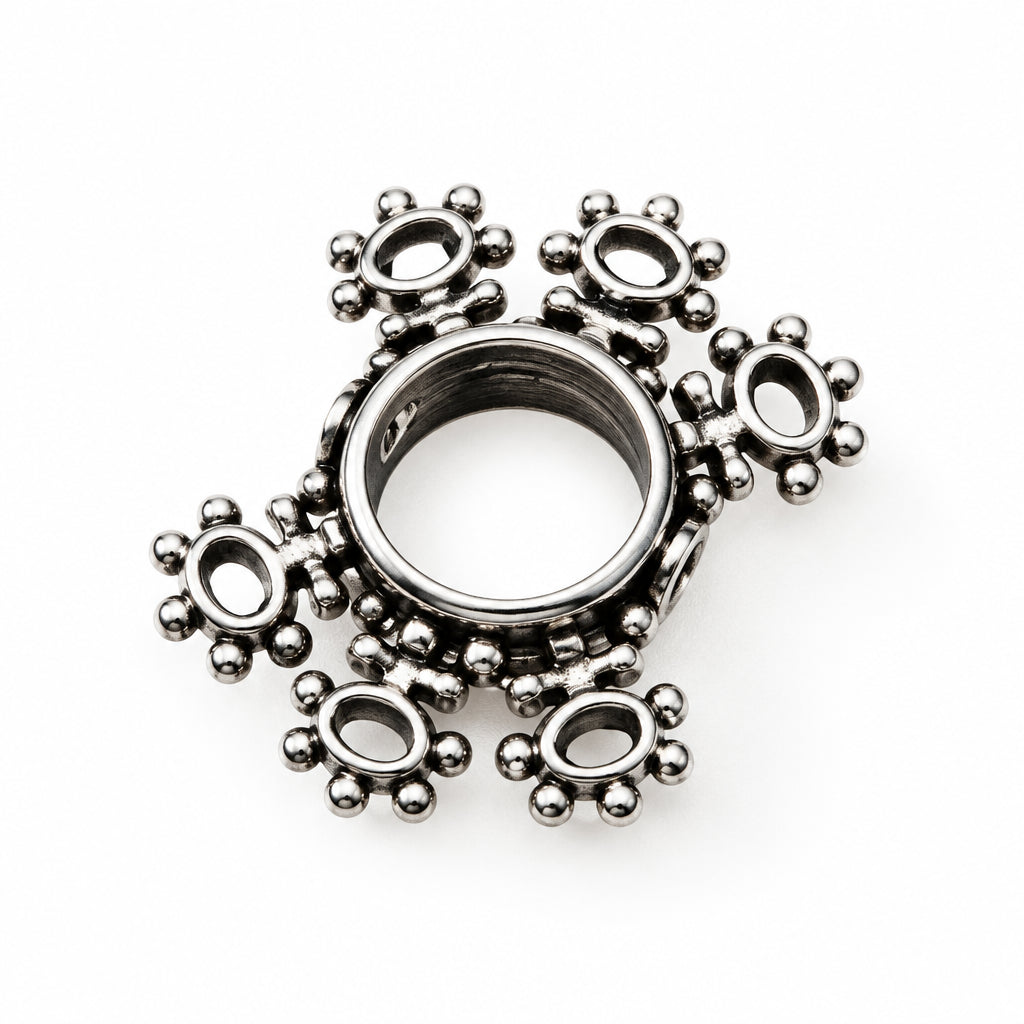 A single silver-toned metal charm with a circular center and five ornate, petal-like extensions, shown on a plain white background.