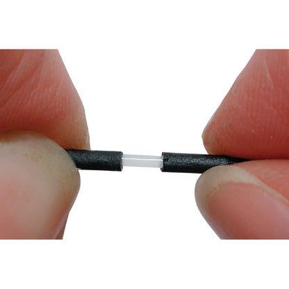 Close-up of a person holding a small black and white cable