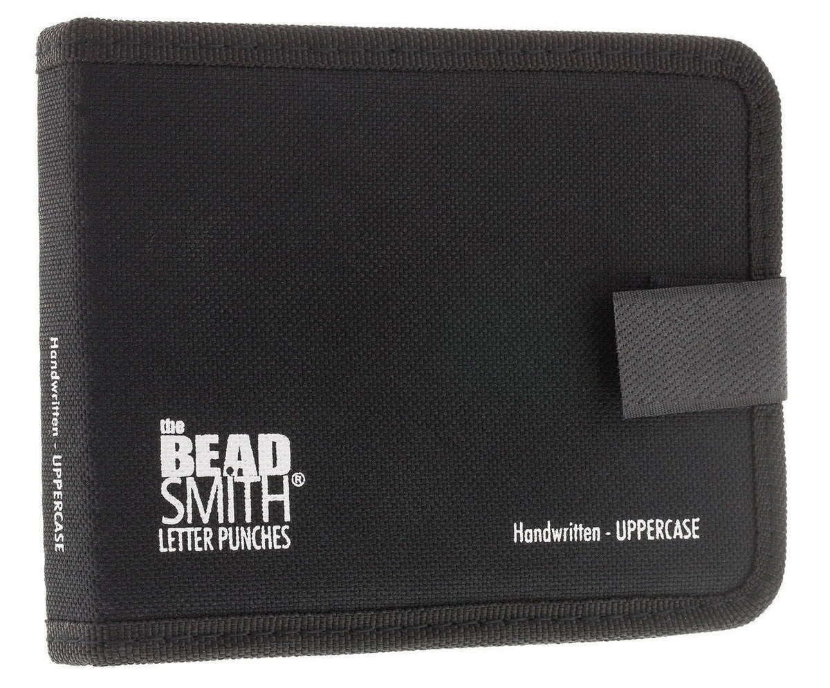 A black canvas letter punch wallet by The Bead Smith, featuring white printed text and a black elastic closure tab on the right side, set against a plain white background.