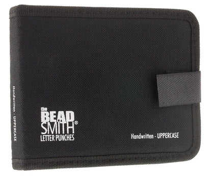 A black canvas letter punch wallet by The Bead Smith, featuring white printed text and a black elastic closure tab on the right side, set against a plain white background.