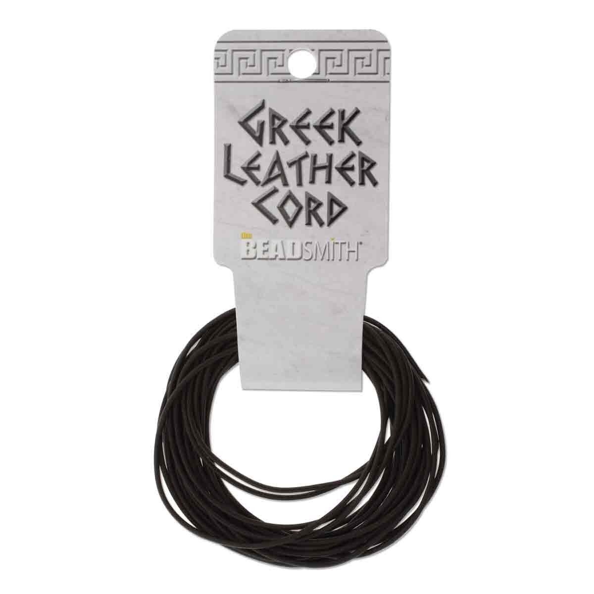 A coiled length of black Greek leather cord attached to a white cardboard hanger with the text 'GREEK LEATHER CORD' and the Beadsmith logo, on a plain white background.