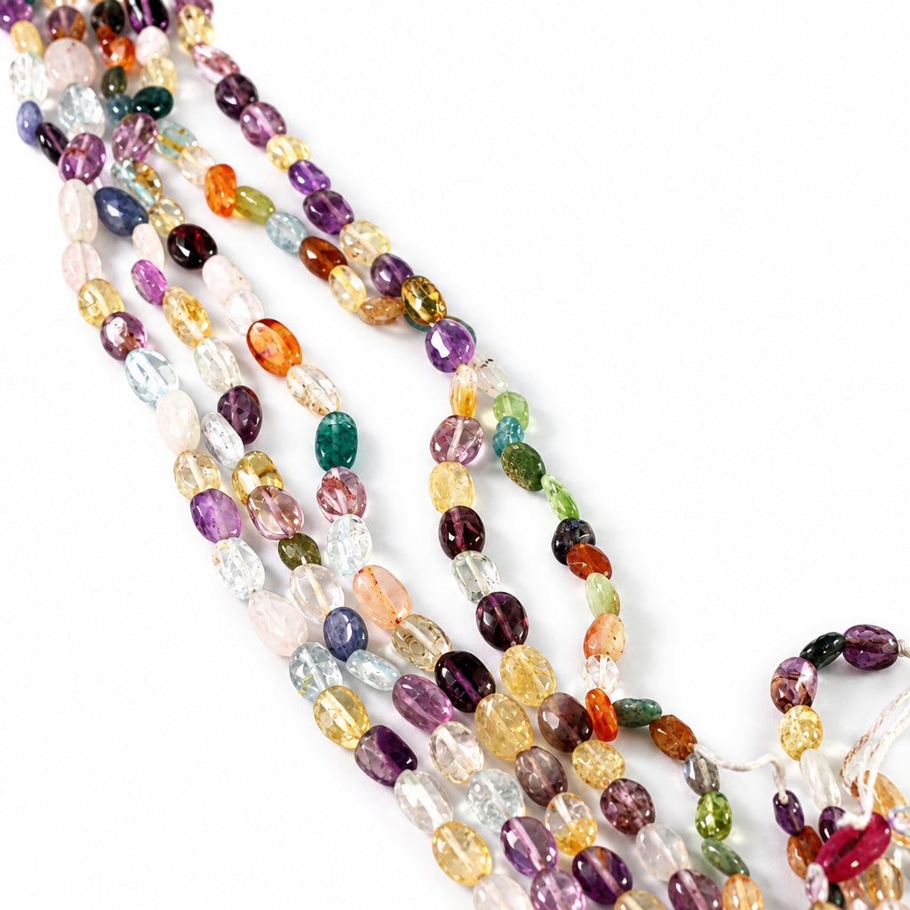Multiple strands of multicolor polished gemstone beads arranged diagonally on a plain white background.