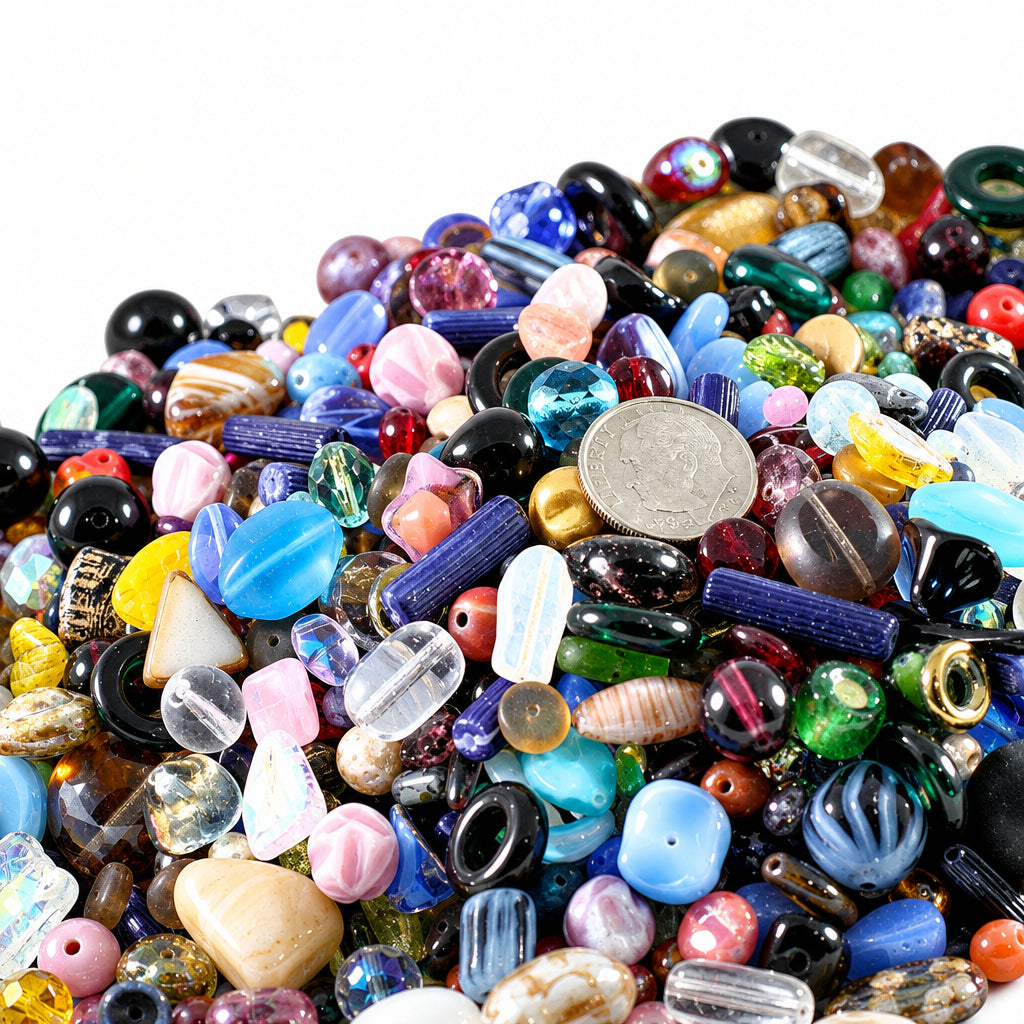 A large pile of assorted craft beads in various colors, shapes, and finishes, with a US quarter coin used as a size reference in the center.
