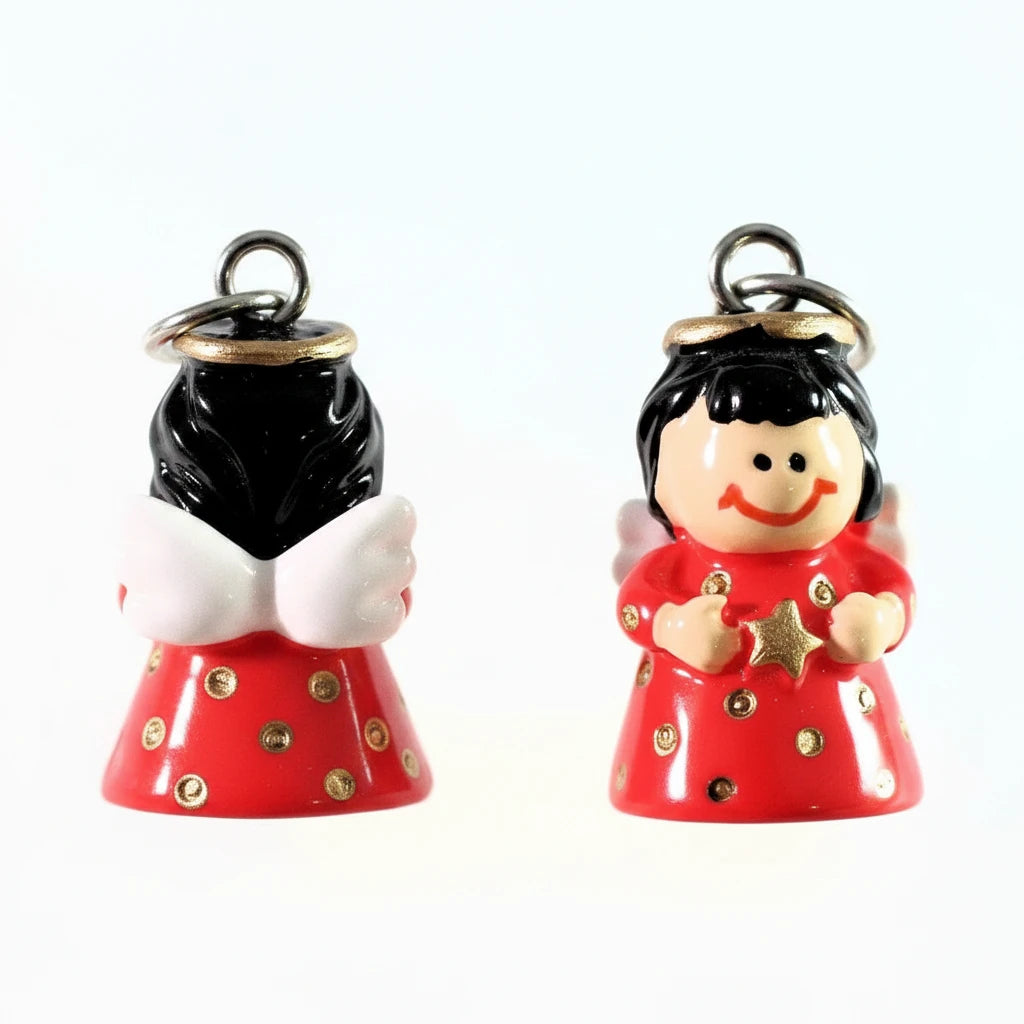 Two small glossy angel figurines on a plain white background. One angel faces forward with black hair, white wings, a red dress with gold polka dots, and a silver hanging loop.