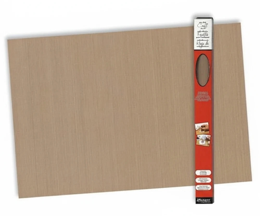 A large rectangular beige textured craft board or mat shown on a white background, with a red and black product package standing vertically along the right edge.