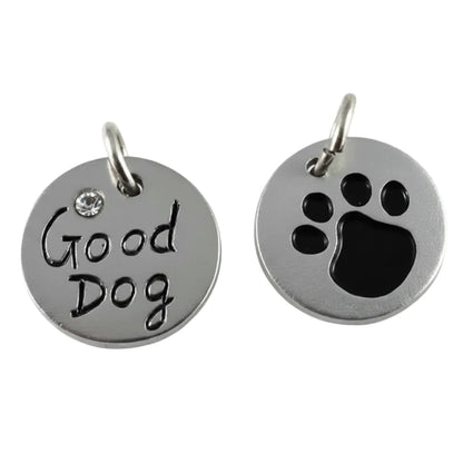 Two round silver metal pet ID tags on a white background. One tag is engraved with 'Good Dog' and has a small clear rhinestone.