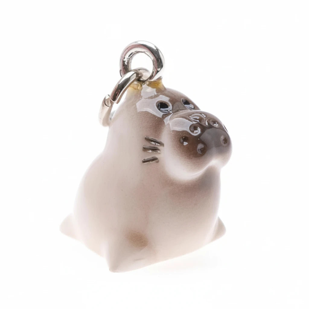 A small seal-shaped charm pendant with a silver metal lobster clasp at the top, shown on a plain white background.