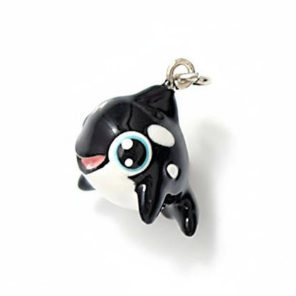 A small black and white cartoon orca charm with a silver clasp, shown on a white background with a '1/2 inch line' size reference below.