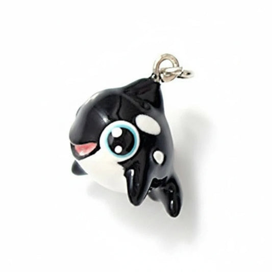 A small black and white cartoon orca charm with a silver clasp, shown on a white background with a '1/2 inch line' size reference below.