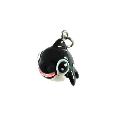 A small black and white cartoon orca charm with a silver metal loop at the top, photographed against a plain white background.
