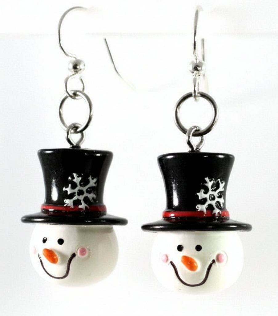 A pair of snowman-themed dangle earrings with black top hats, red bands, and smiling white faces on silver fishhook wires, shown against a plain white background.