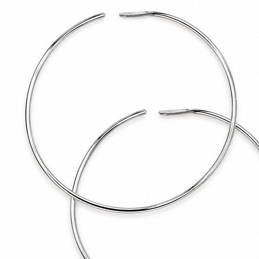 Two thin silver metal hoop earrings overlapping on a plain white background.