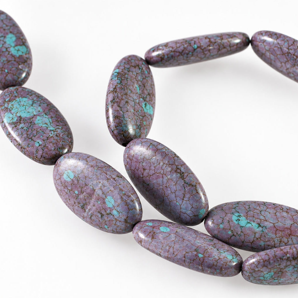 A strand of polished oval beads in a purple and pink marbled stone with bright turquoise blue matrix inclusions, shown on a plain white background.