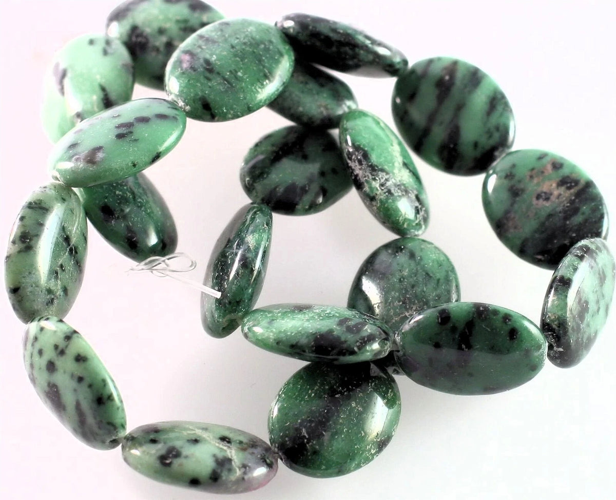 A strand of polished green jasper oval beads with dark brown and black veining, displayed on a plain white background.
