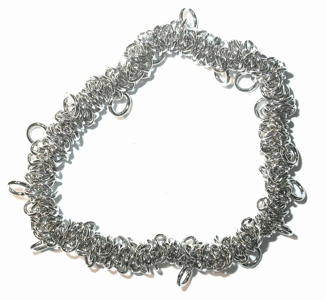 A handmade silver chainmail bracelet made of interwoven metal rings, photographed on a plain white background.