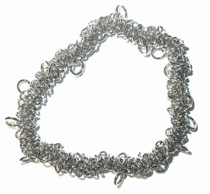 A handmade silver chainmail bracelet made of interwoven metal rings, photographed on a plain white background.
