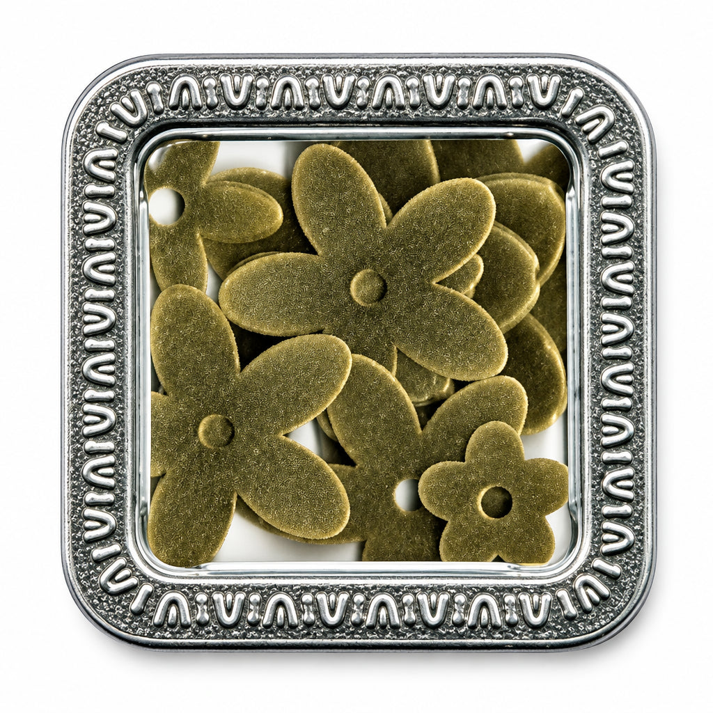 A square metal tin with a decorative embossed border and a clear top, containing several small flower-shaped metallic embellishments or charms in a warm metallic gold tone, shown on a white background.