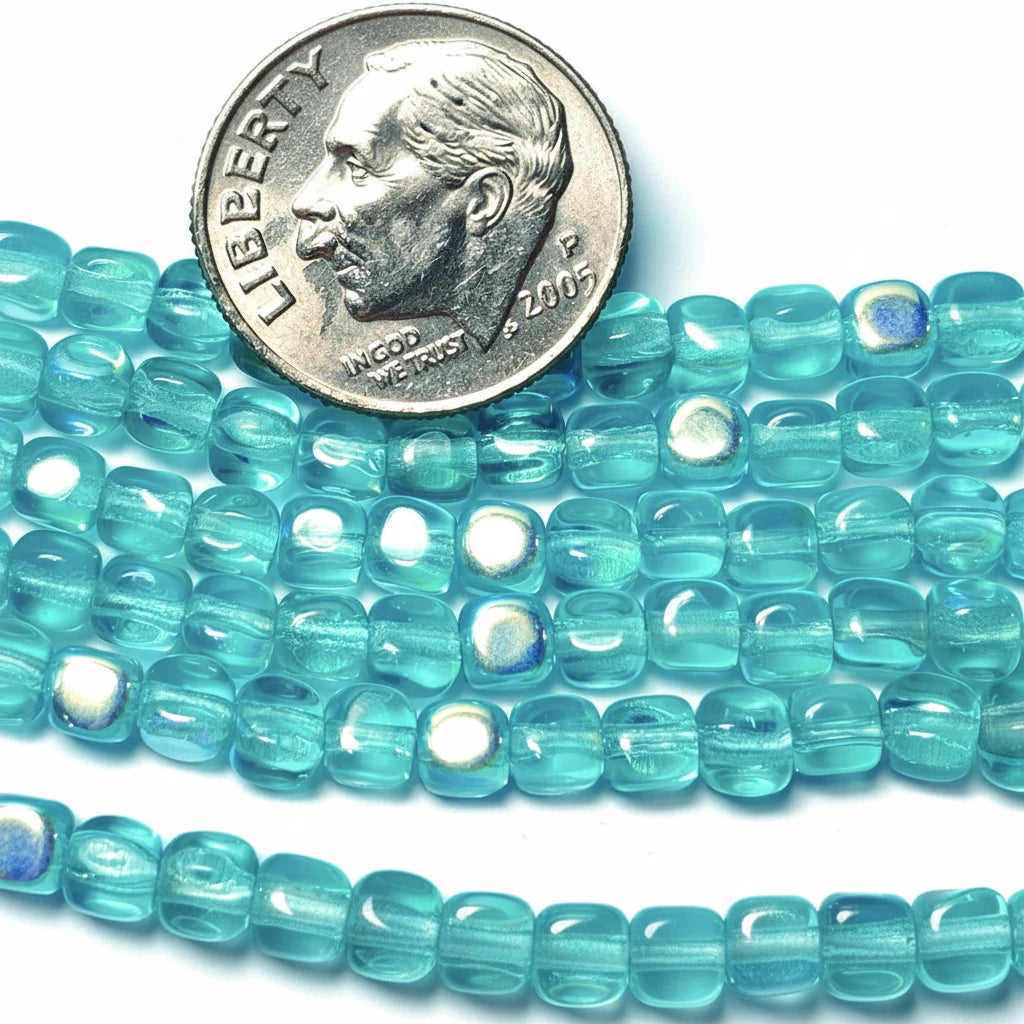 Turquoise glass seed beads with a glossy finish, shown in multiple strands with a US quarter coin for scale.
