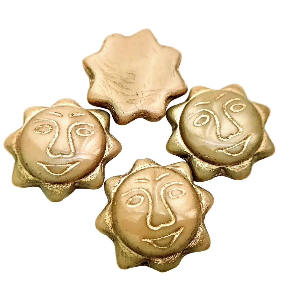 Four metallic gold sun-shaped beads with engraved facial features, one flat bead, and one broken piece, displayed on a white background.